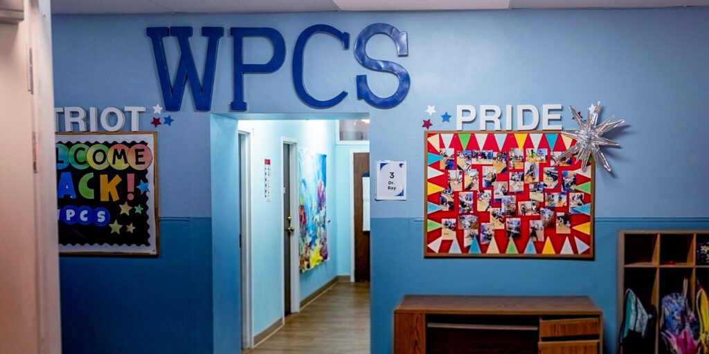 Washington Park Community School hallway with photo boards for school pride and "WPCS" in large letters
