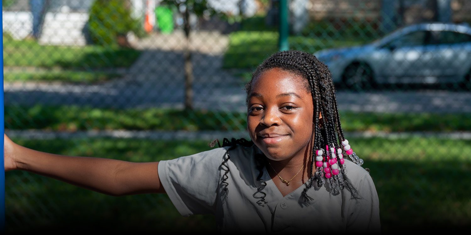 Smiling student outside on the playground of the school campus